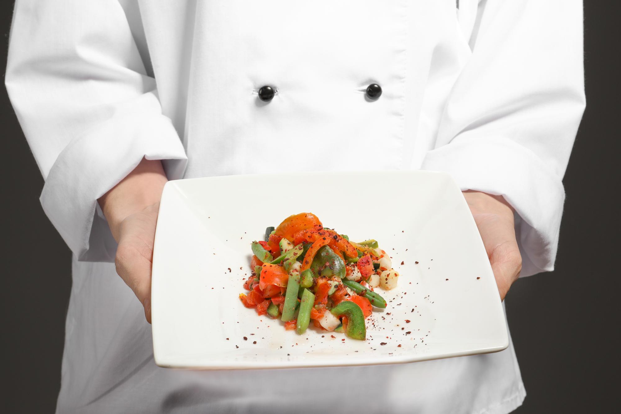 Chef che mostra un piatto finito durante una lezione